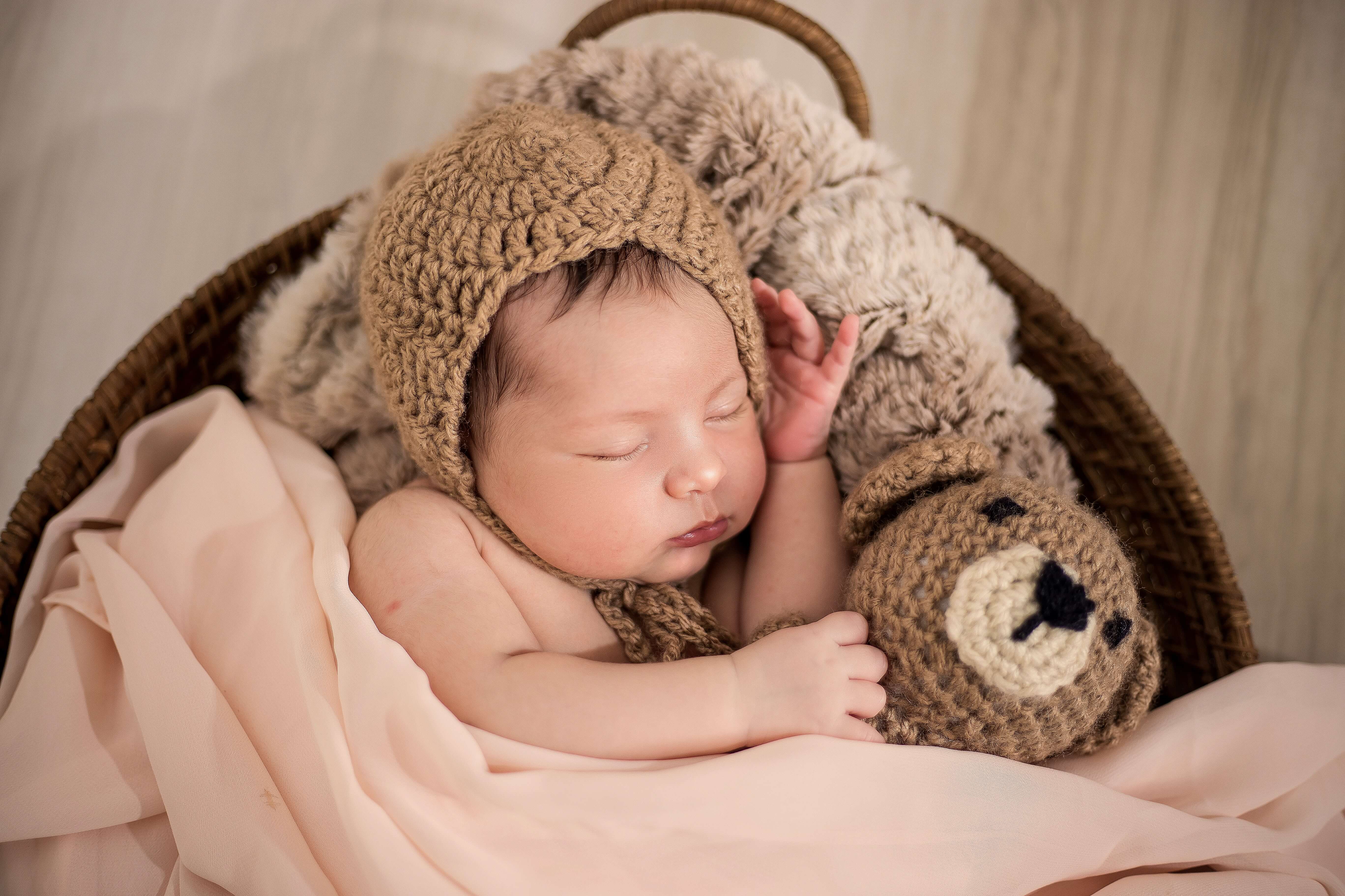 Sleeping baby cuddling a stuffed animal