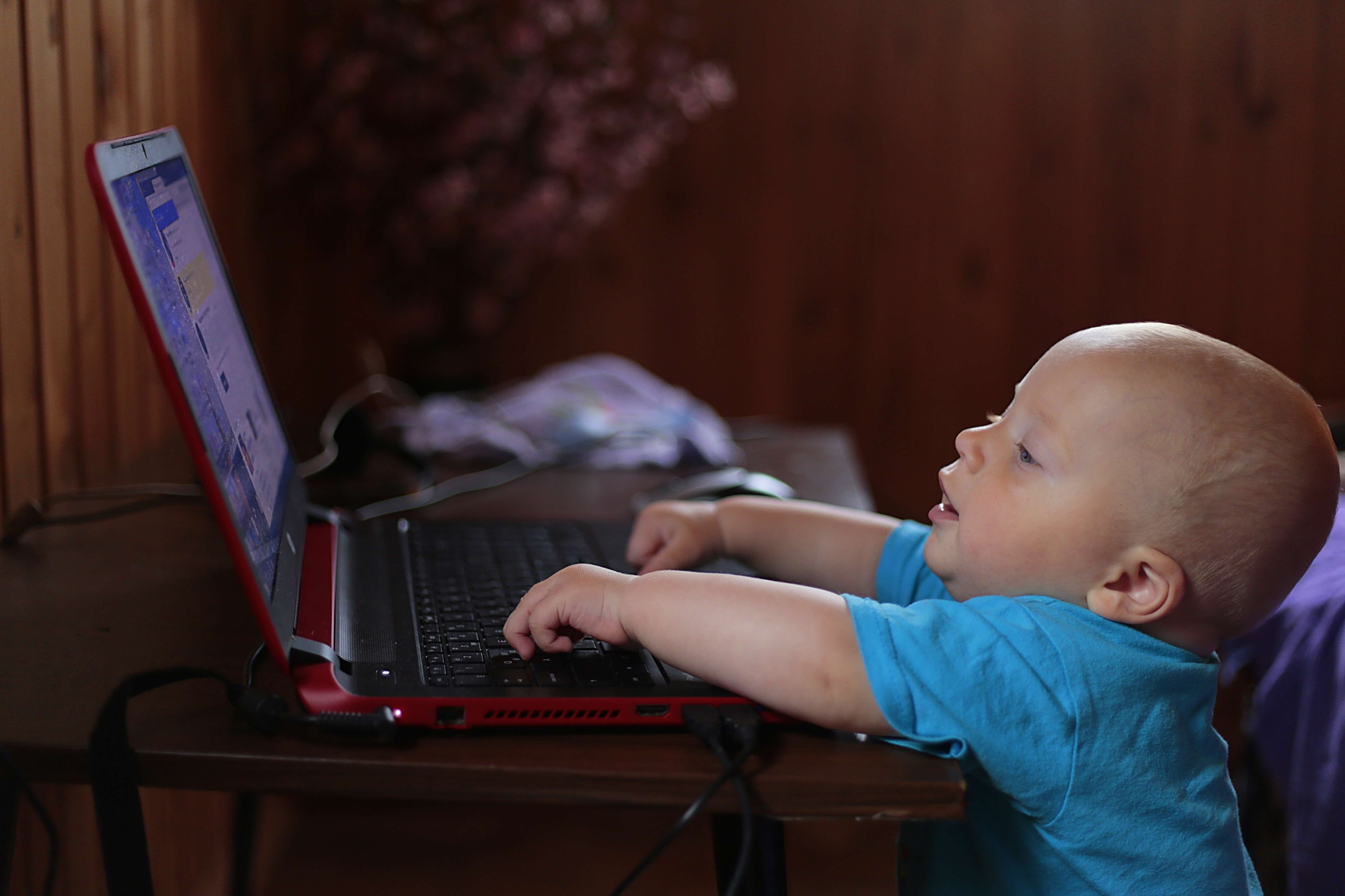 Baby boy playing on a laptop