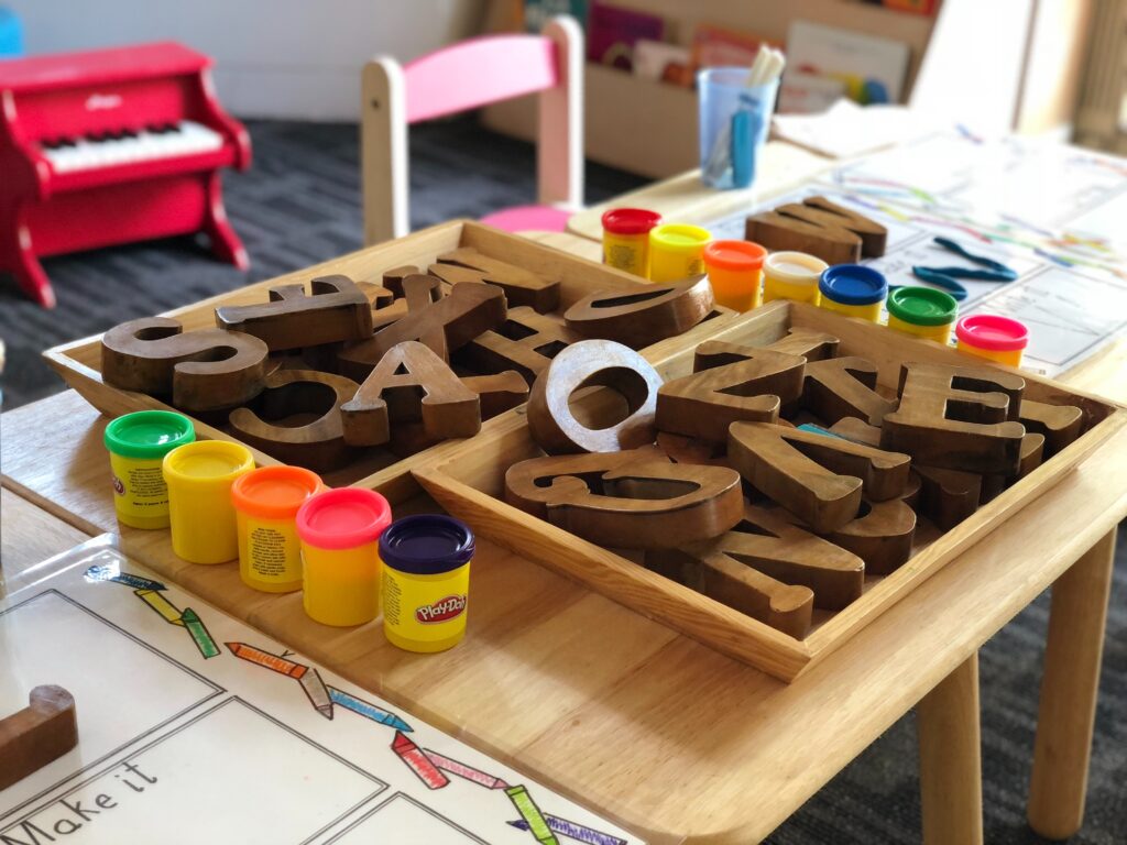 Daycare room activity table with block letters and playdoh